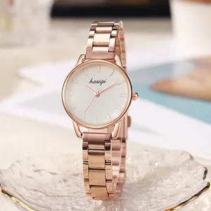 Montre élégante en acier or rose avec cadran blanc minimaliste sur plateau en verre