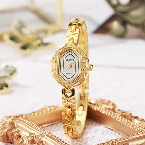 Elegant gold vintage bracelet watch with hexagonal dial and ornate metal strap for women