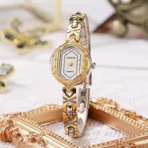 Detail of vintage quartz watch with embossed hexagonal dial and two-tone metal strap
