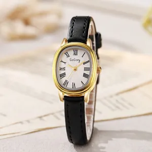 Détail d'une montre ovale dorée élégante avec chiffres romains et bracelet en cuir