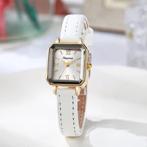 Détail de la montre carrée vintage pour femme avec cadran doré et bracelet en cuir blanc