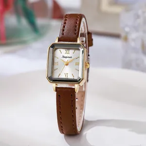 Détail du boîtier carré doré avec chiffres romains et bracelet en cuir marron pour femme