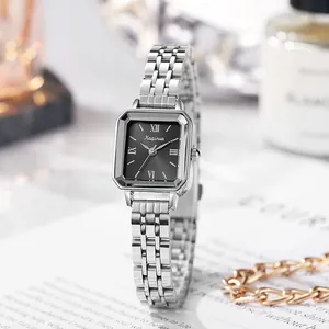 Détail d'une montre femme avec cadran carré noir et bracelet en acier argenté à maillons