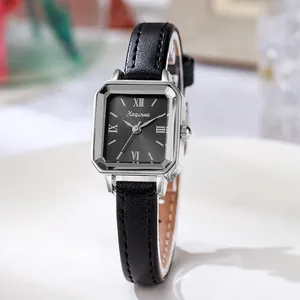 Detail view of square silver watch with black roman dial and leather strap