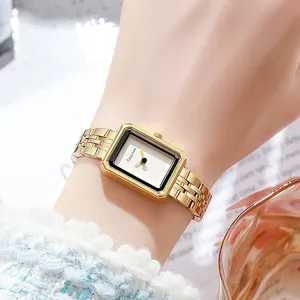 Vintage style gold rectangular watch with black inner frame on female model wrist