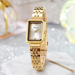 Elegant gold rectangular ladies watch with stainless steel band on marble base