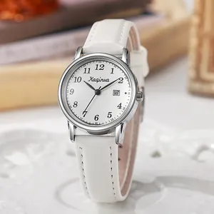 Macro shot of silver women's watch featuring white leather strap and date display