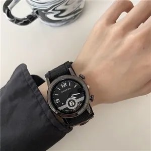 Detailopname van een zwart sportief quartzhorloge met nylon band en datum op een pols