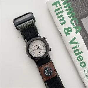 Detail van militair kwartshorloge met groene canvas band en mini-kompasfunctie