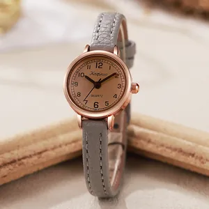 Elegante Roségold-Quarzuhr mit schmalem grauem Lederarmband und champagnerfarbenem Zifferblatt