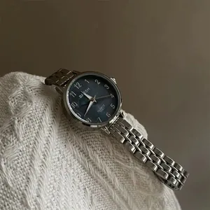 Détails du bracelet en acier argenté et cadran bleu marine sur tissu en maille blanche