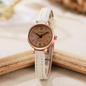 Details einer roségoldenen Quarzuhr mit weißem Lederarmband und champagnerfarbenem Zifferblatt