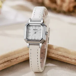 Detail of silver octagonal square watch with white leather strap and minimalist dial