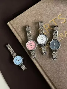 Détail de quatre montres à quartz pour femmes avec bracelets en acier argenté