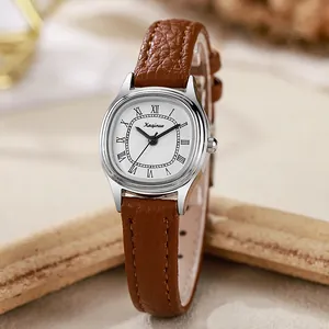 Macro detail of silver tonneau case with Roman numerals and brown leather strap texture