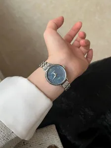 Gros plan d'une montre BARSH pour femme avec cadran bleu et bracelet en acier au poignet