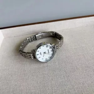Détail d'une montre à quartz en métal argenté avec cadran blanc et chiffres