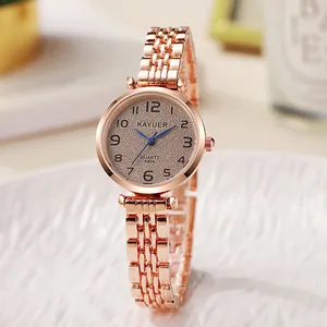 Detail van roségouden kwartshorloge met korrelige wijzerplaat en metalen schakelarmband