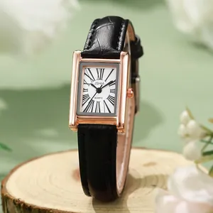 Macro shot of vintage rectangular rose gold watch with roman numerals and black leather strap