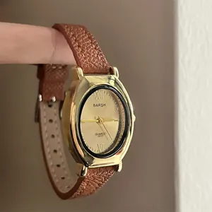 Montre à quartz élégante pour femme avec boîtier ovale doré et bracelet en cuir marron chic