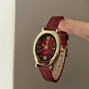 Vue détaillée de la montre à quartz ovale avec bracelet en cuir rouge et boîtier doré