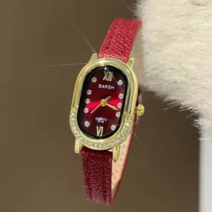 Detail van een rode wijzerplaat met Romeinse cijfers en diamanten accenten op gouden rand