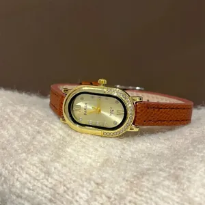 Detailopname van de gouden kast met kristallen en bruine leren band op zachte witte stof
