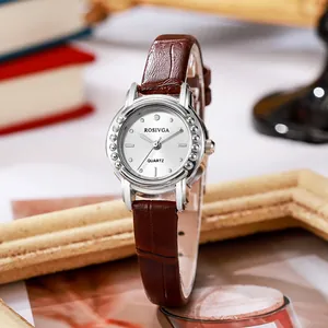 Elegant vintage dameskwartshorloge met bruine leren band en zilveren wijzerplaat op bureau