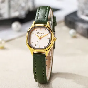 Detail of vintage gold rectangular watch case with dark green leather strap and white dial