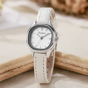 Detail of silver tonneau quartz watch with white leather strap on a minimalist background