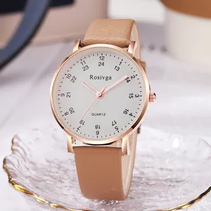 Minimalist quartz watch with rose gold case and brown leather strap on elegant tray