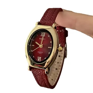 Montre quartz ovale dorée avec bracelet en cuir bordeaux et chiffres romains