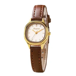 Retro small dial ladies watch with gold case and brown leather strap on white background