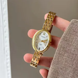 Dettaglio dell'orologio da donna ovale dorato al quarzo con cinturino a catena e quadrante