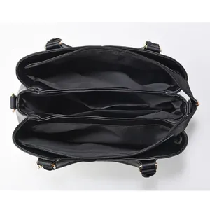 Vue de dessus de l'intérieur du sac noir avec trois compartiments et détails dorés
