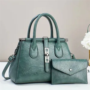 Detail of dark green lychee textured doctor bag set with crossbody strap and metal buckle