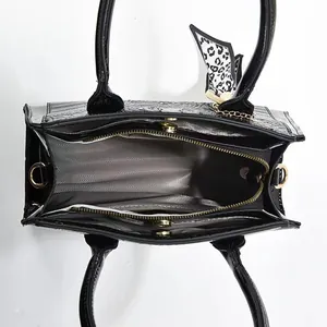 Top view of crocodile pattern handbag interior with compartment and leopard scarf detail