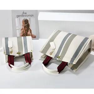 Minimalist striped canvas tote bags for women featuring premium leather handles and gold buckles