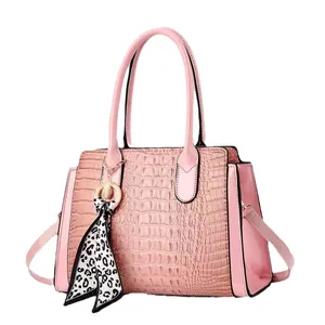 Pink crocodile-embossed handbag with patent leather details and leopard print scarf