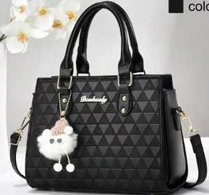 Détail du sac bandoulière noir avec texture tissée triangulaire et logo doré chic