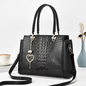 Sac à main noir à relief crocodile avec détails dorés et pendentif perle