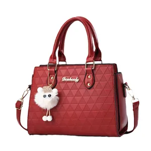 Sac à main rouge en similicuir avec motif triangle gaufré et pendentif en peluche blanc