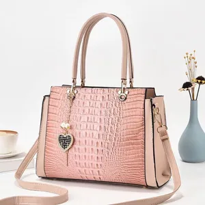Sac à main élégant rose poudré avec motif crocodile et pendentif cœur amovible