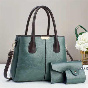 Set de bolsos de cuero sintético verde oscuro con asas marrones y detalles metálicos dorados