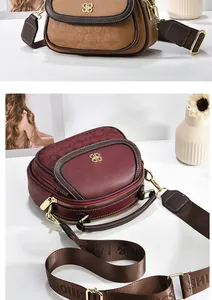 Detail of multi-pocket leather handbags with circular embossing and dual zippers