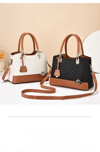 Detail of color-block tote bags with geometric texture, metal hardware, and shoulder strap