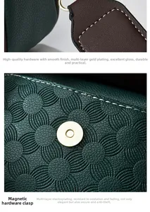 Close-up of floral embossed leather texture and gold-plated lobster clasp of the handbag