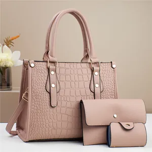 Detalle del conjunto de tres bolsos rosa nude con relieve de cocodrilo y herrajes oro