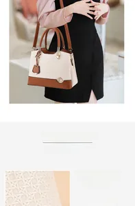 Detail of color-block tote bag featuring textured fabric and polished metal hardware logo