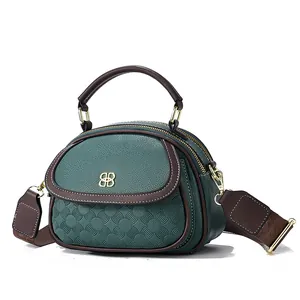 Deep green and brown leather crossbody handbag with dual zippers and floral embossed pattern